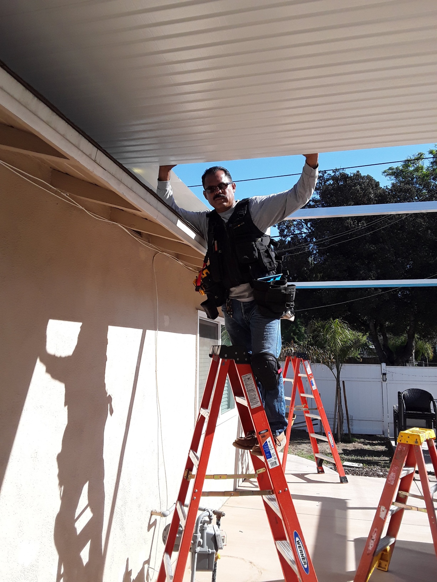 Alpha One installer fitting a glass panel during a sunroom build